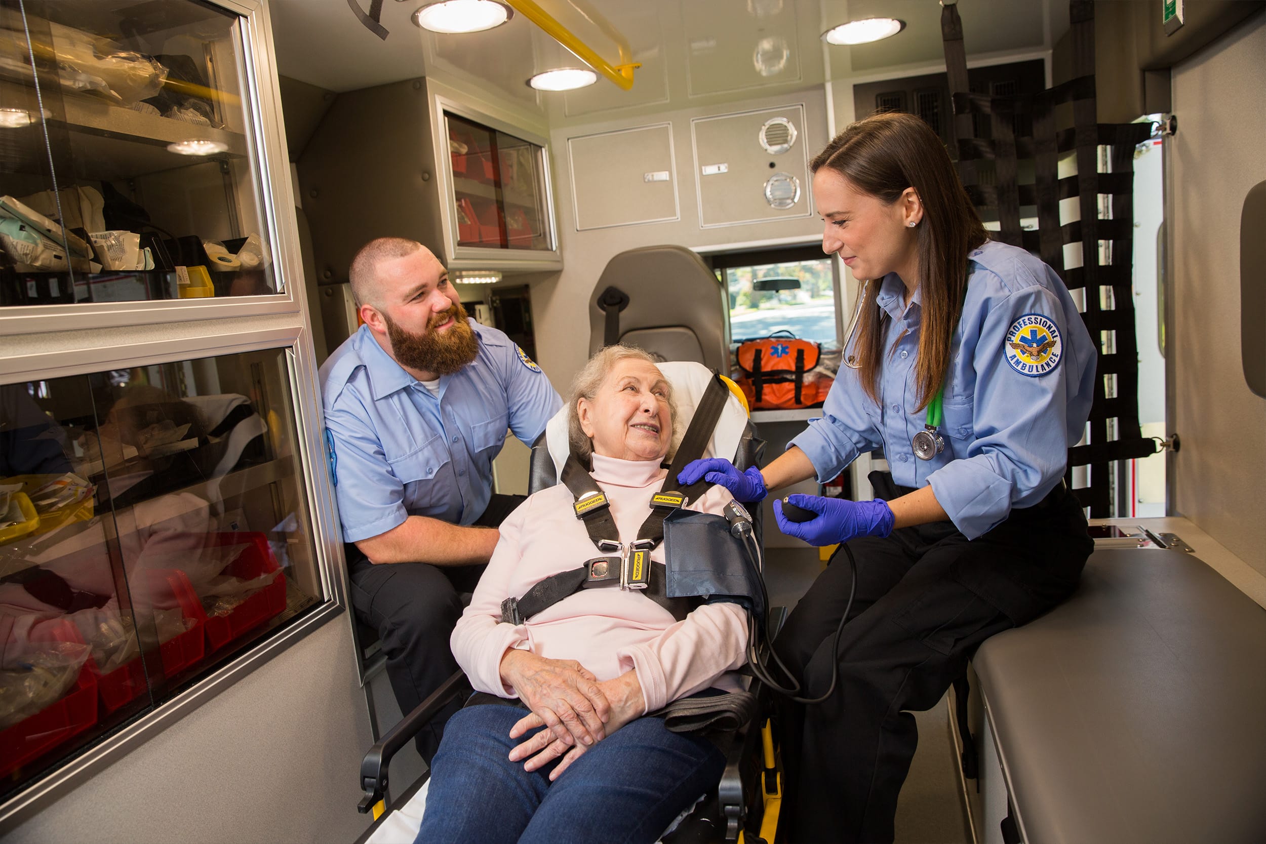 EMT laughing with women in back of Ambulance