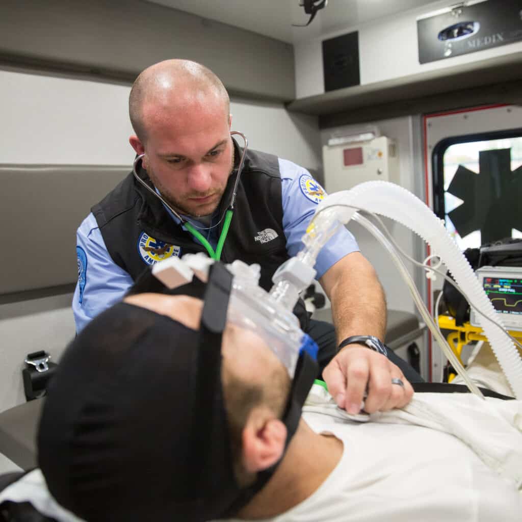 EMT helping man in back of Ambulance