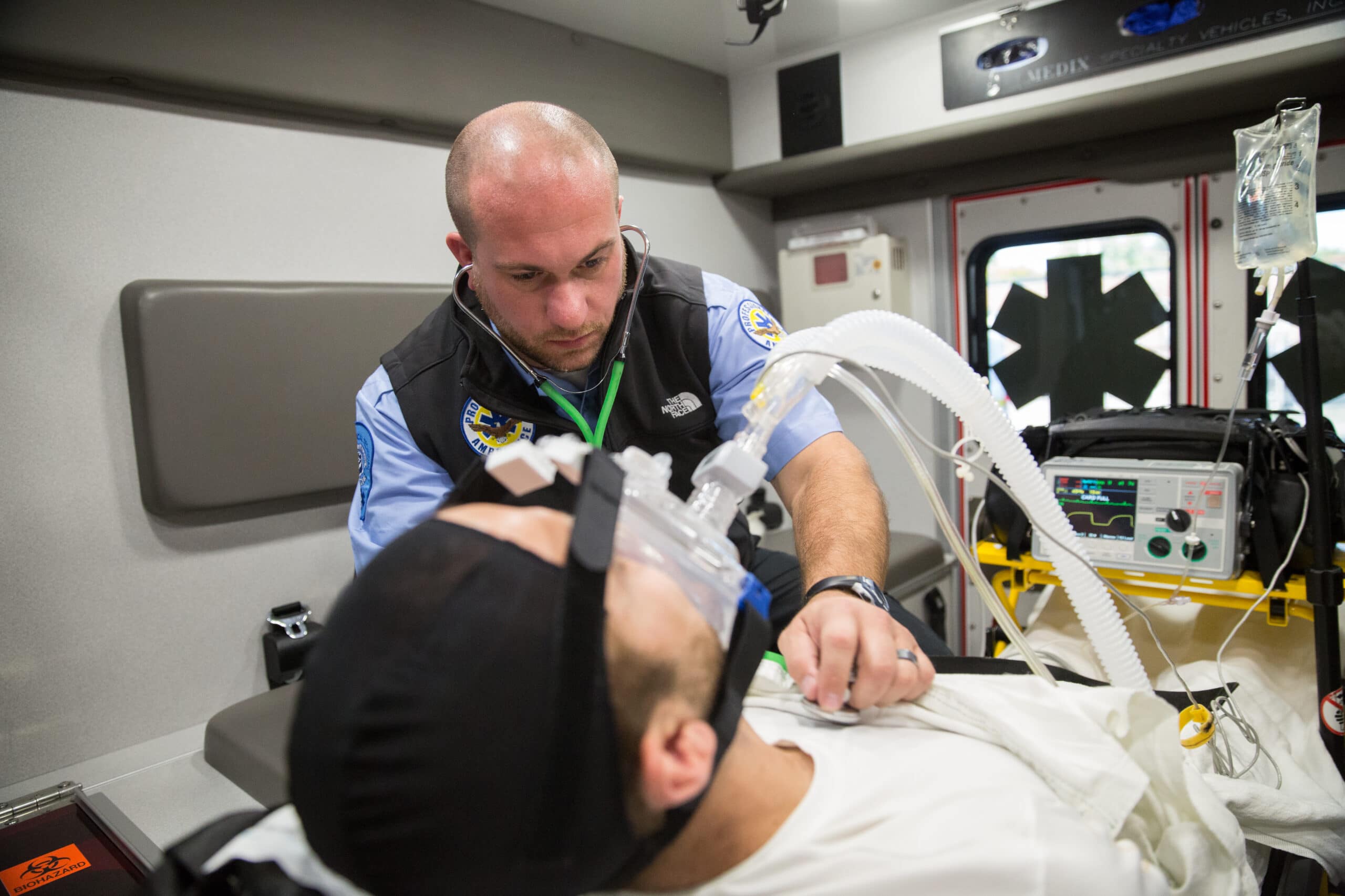 EMT assisting man in back of ambulance