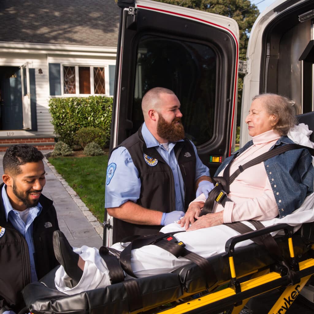 Two male EMTs helping elderly women